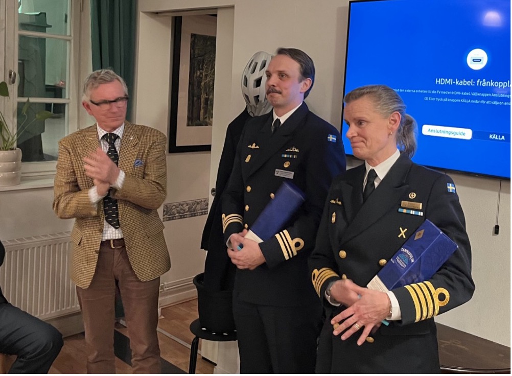 Ordförande Olle Fernström tackar C1ubflj kmd Paula Wallenburg och örlkn Daniel Hakkarainen